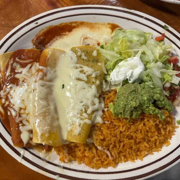 A plate of La Cantina Mexican food with enchiladas, rice, guacamole, and salad.